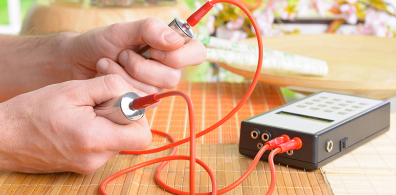 Hands holding biofeedback therapy handles as a natural fibromyalgia treatment