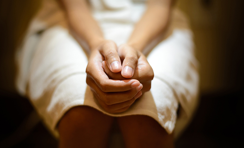 Patient sitting with hands clasped together