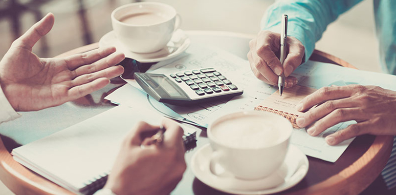 Two people talk business over coffee