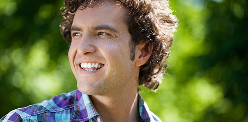 A man is smiling while enjoying nature