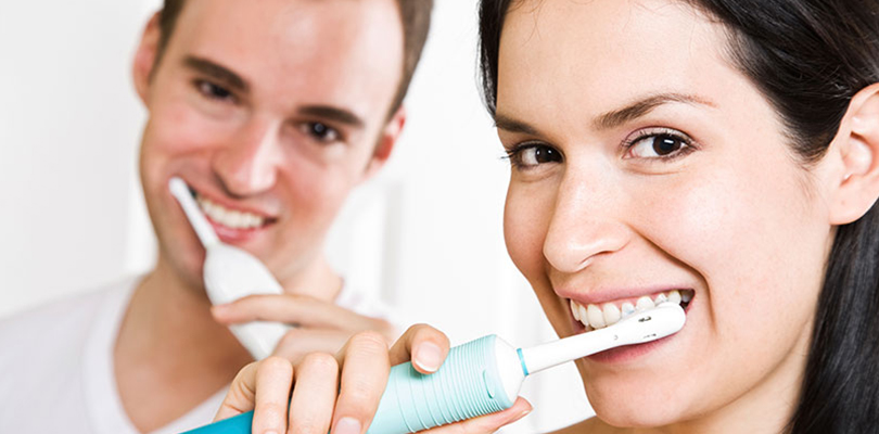 A couple are brushing their teeth