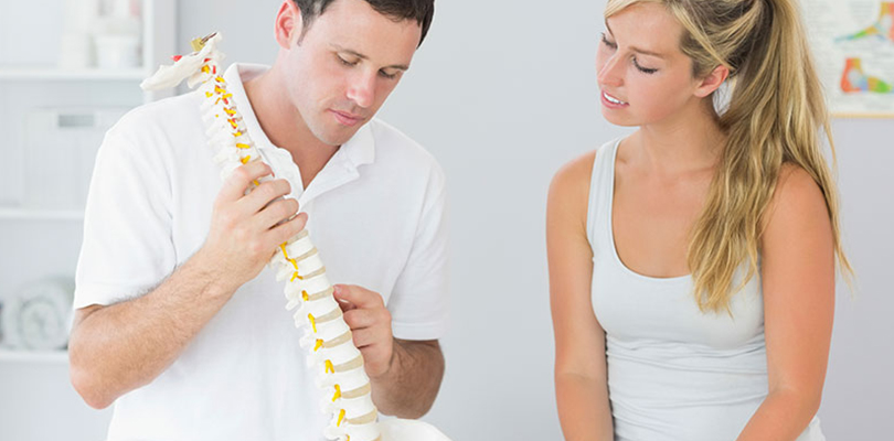 Woman is listening to her chiropractor explain good posture