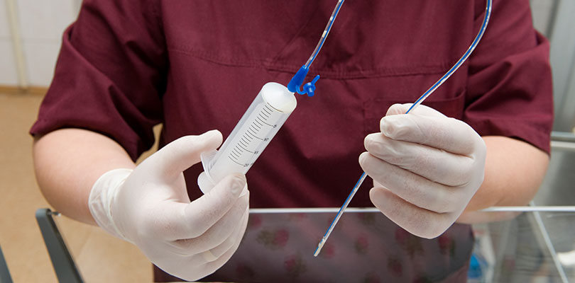 A man is holding a feeding tube