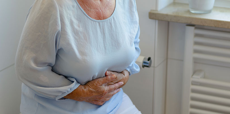 Older woman is clenching her stomach
