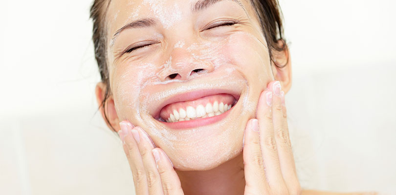 Woman is cleansing and washing her face