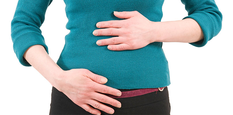 An individual is holding their bloated and gassy stomach