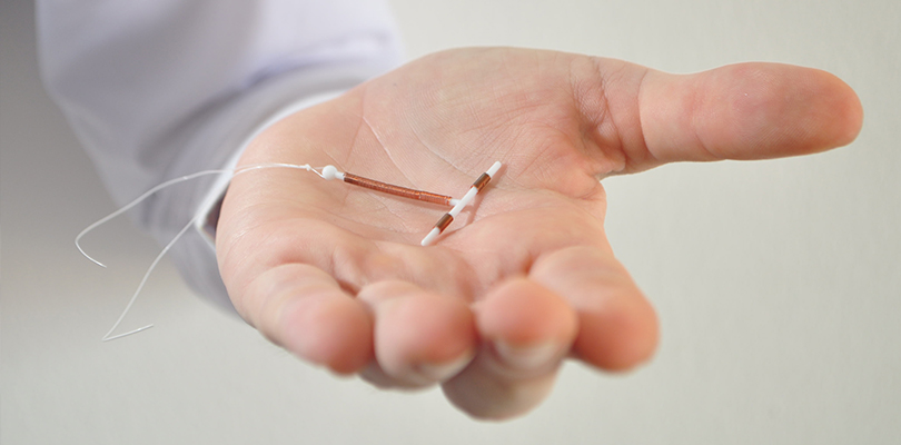 An IUD in the palm of a person's hand