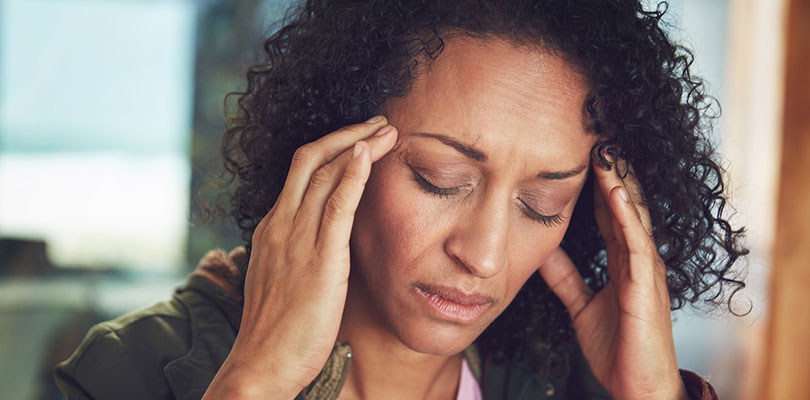A woman is experiencing a migraine