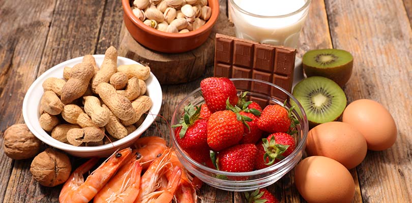 Strawberries, shellfish, peanuts, tree nuts, eggs and milk are on a table