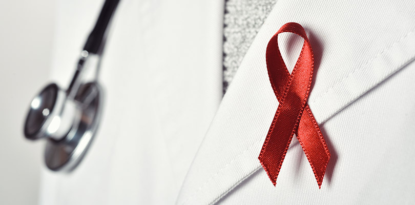 A doctor is wearing a HIV/AIDS ribbon