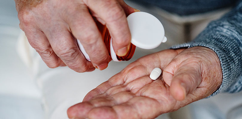 Person holding white medication tablet