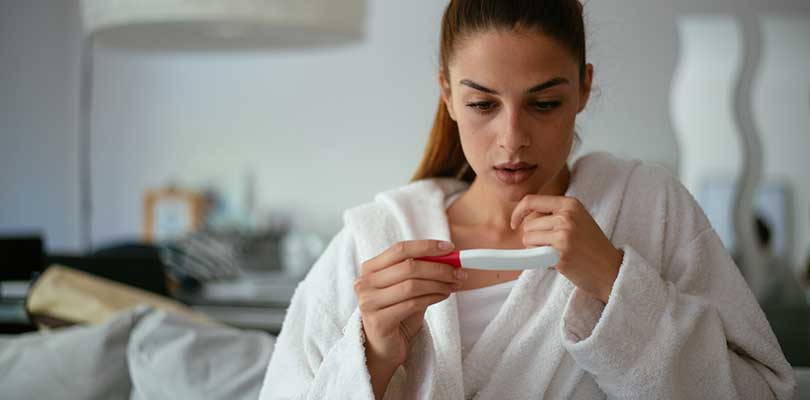 A woman looking at a pregnancy test