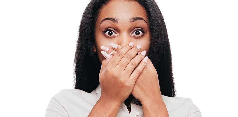 A woman covering her mouth after a hiccup