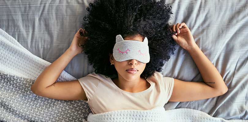 A woman wearing a sleep mask, sleeping